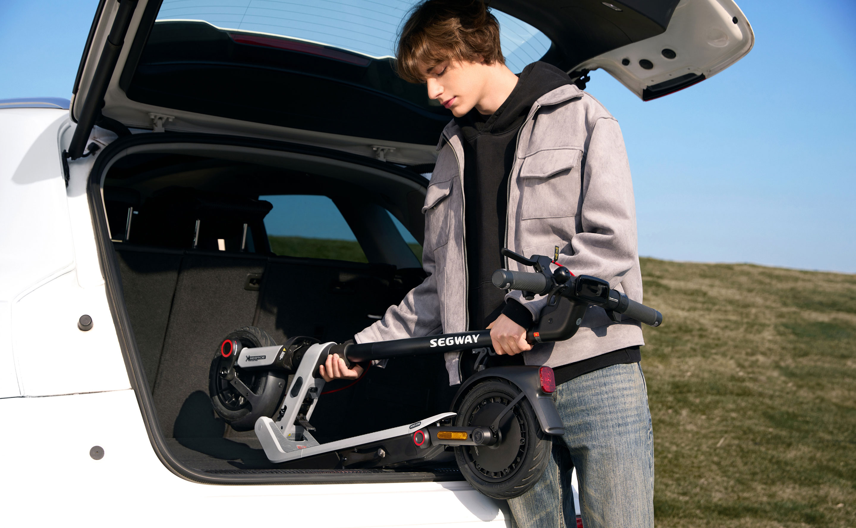 Folded Segway E3-series scooter being placed into a car boot